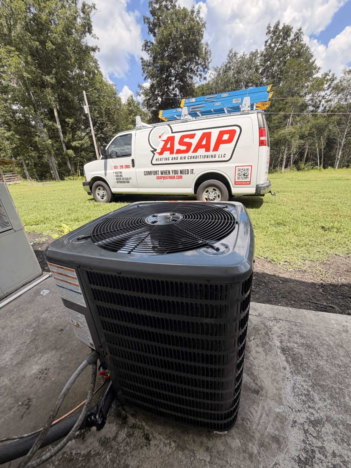 ASAP Heating and Air-Conditioning LLC branded service van parked behind an outdoor AC condenser during a residential heating and cooling service call in Hickman County, Tennessee.